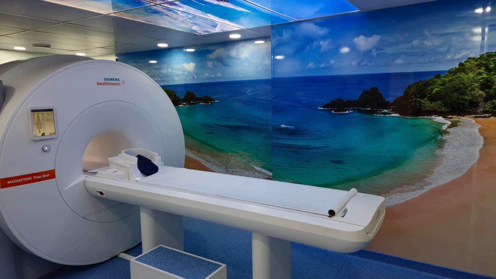 Ressonância MAGNETOM Free.Star vista de lado, com o mural de Fernando de Noronha